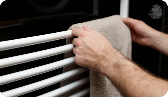 mężczyzna wieszający ręcznik na grzejniku drabinkowym